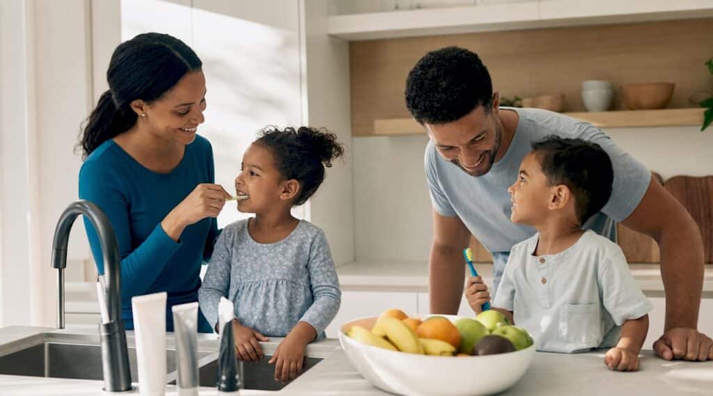 Family brushing teeth together in bathroom